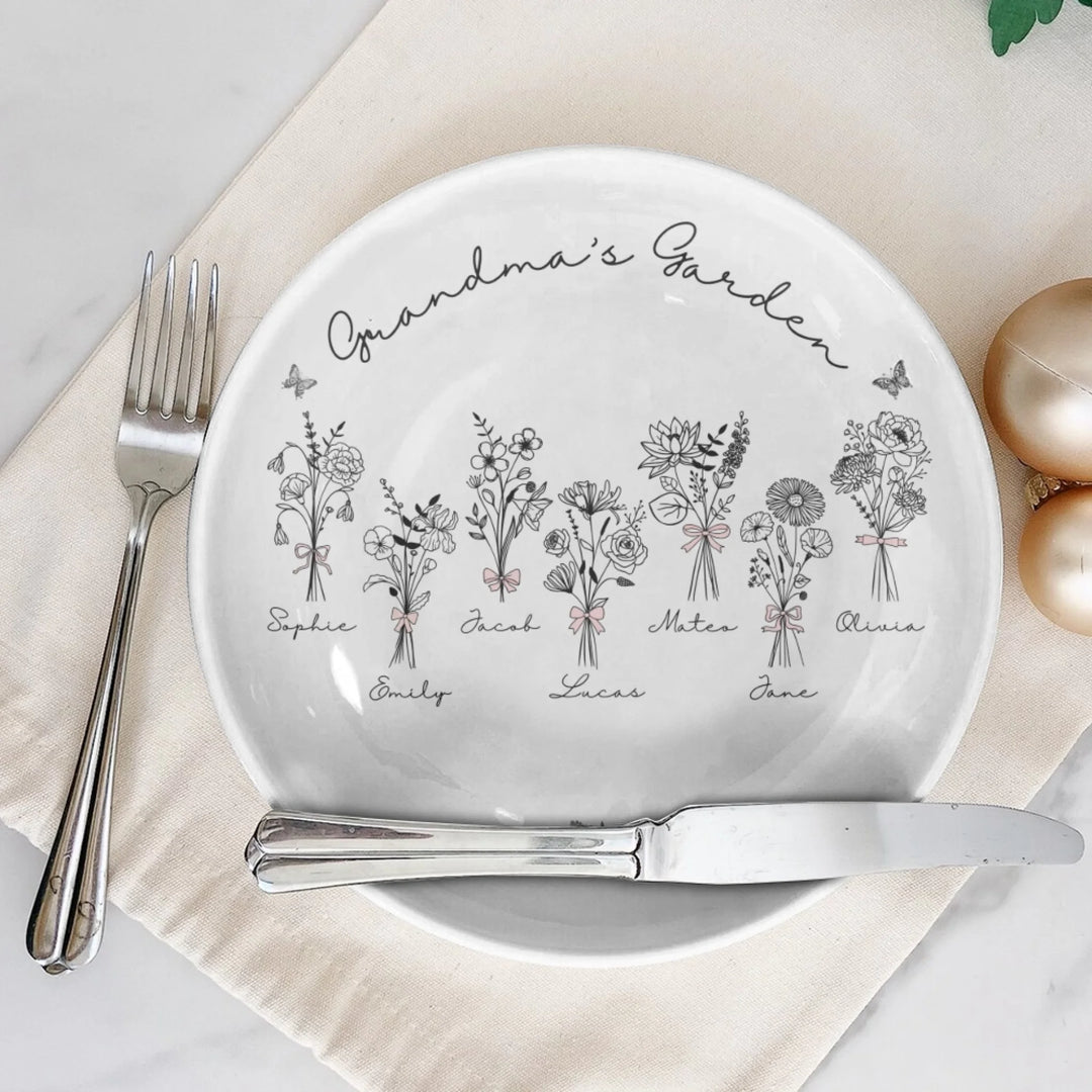 On table - Custom coquette birth flowers ceramic plate with stand featuring 12 delicate floral designs, personalized names, and custom title in any color by ARTFULANE