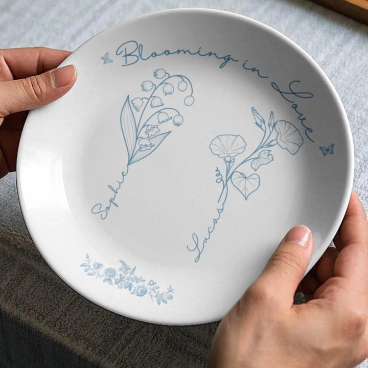 In hands - Custom line art birth month flowers ceramic plate with stand featuring names attached to floral stems in any color by ARTFULANE