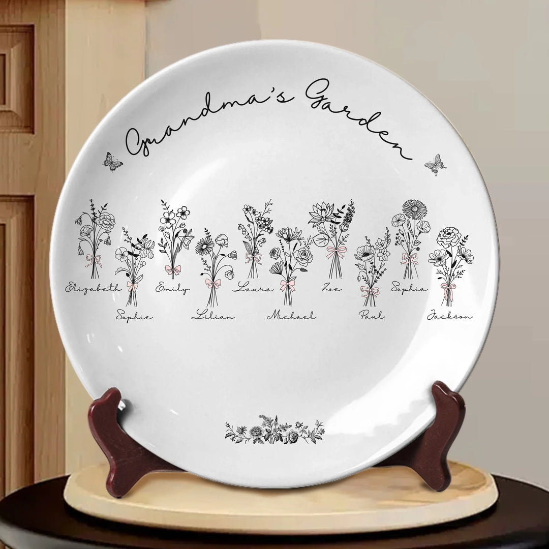 Custom coquette birth flowers ceramic plate with stand featuring 12 delicate floral designs, personalized names, and custom title in any color by ARTFULANE