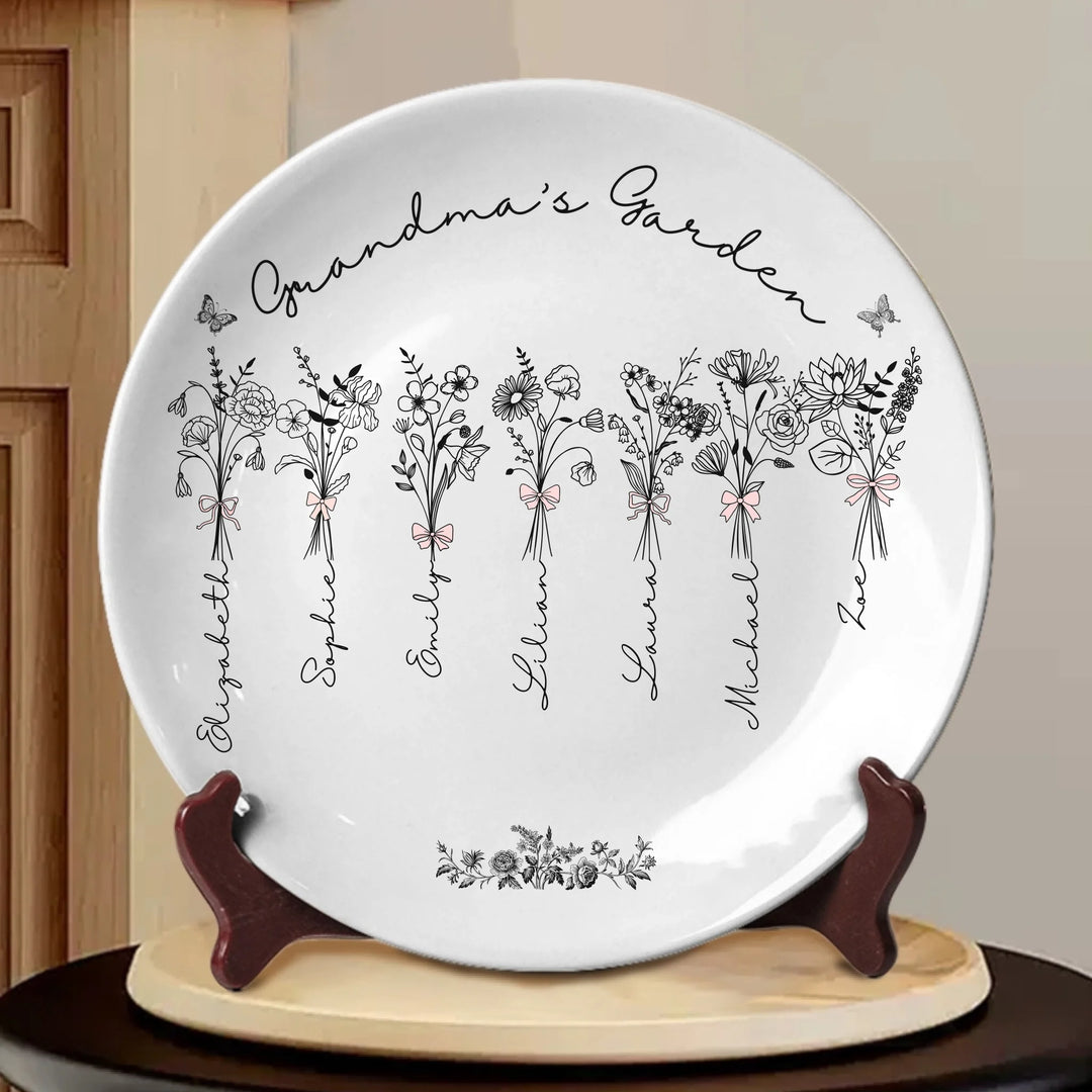 Custom Coquette birth month flowers ceramic plate with stand featuring delicate floral line art, custom family names, and optional butterflies, available in any color by ARTFULANE