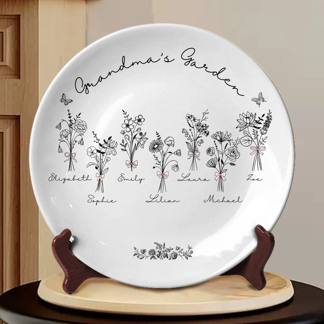 Custom coquette birth flowers ceramic plate with stand featuring 12 delicate floral designs, personalized names, and custom title in any color by ARTFULANE