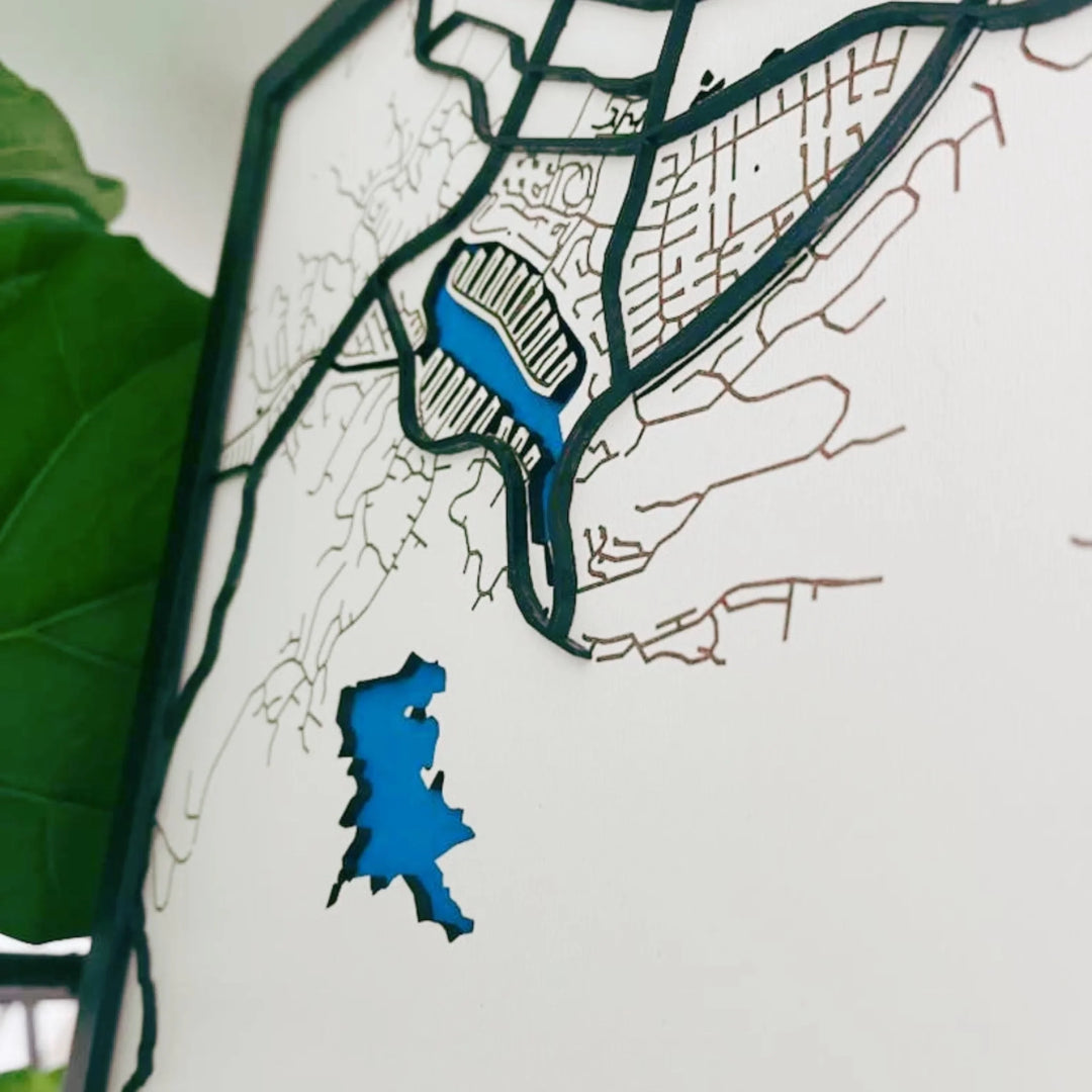 Close-up of four-layer custom wooden map showing painted water, engraved land, and cut street details-ARTFULANE